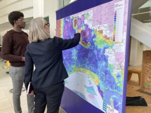 A woman and a man look at a map showing the region's flood risk